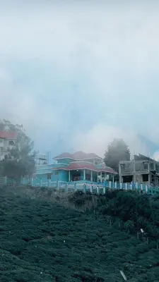 a group of houses on a hill in a field at Kalon Elpis Villa in Ooty