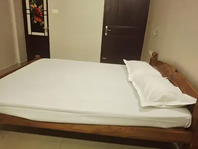 a bed with white sheets and pillows in a room at Aqua Vista beach home's in Cochin