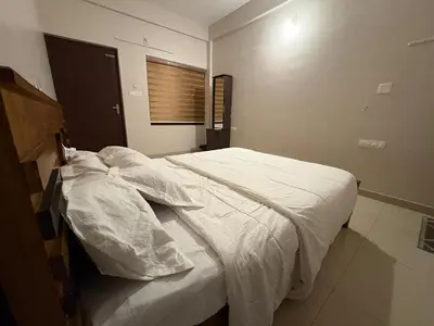 a bedroom with a large bed with white sheets at Aqua Vista beach home's in Cochin