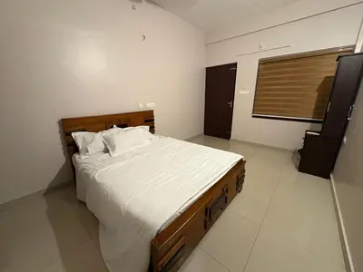 a bedroom with a large bed with white sheets at Aqua Vista beach home's in Cochin