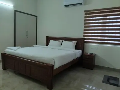 a bedroom with a large bed with white sheets at Amaira Studio living - Coimbatore in Coimbatore