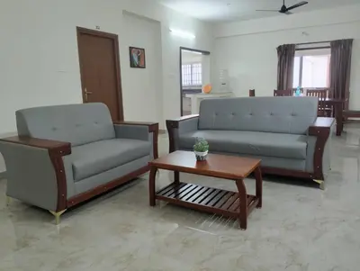 a living room with two couches and a coffee table at Amaira Studio living - Coimbatore in Coimbatore