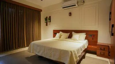 a bedroom with a bed with white sheets and a window at Mizuki Homestay in Trichūr