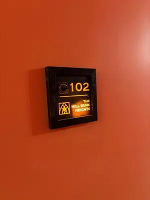 a clock on an orange wall with the number at The Hill Bunk Heights Ooty in Ooty