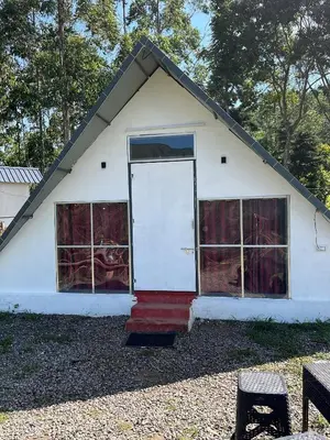 a small white house with a large white door at Vattavada budget cottages & Aframe in Vattavada