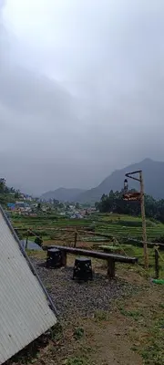 a picnic table in a field with a swing at Vattavada budget cottages & Aframe in Vattavada