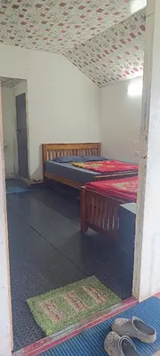 a room with two beds and mats on the floor at Vattavada budget cottages & Aframe in Vattavada
