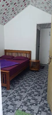 a bedroom with a bed with purple sheets and a doorway at Vattavada budget cottages & Aframe in Vattavada