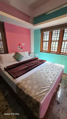 a large bed in a room with colorful walls at Azhagumail Honey Resort Kanthalloor in Kanthalloor