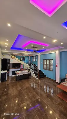 a living room with purple lights on the ceiling at Azhagumail Honey Resort Kanthalloor in Kanthalloor