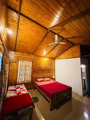 a bedroom with a red bed and a wooden ceiling at sireesha estate cottage stay in Madikeri
