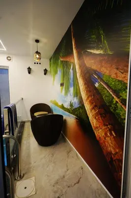a bathroom with a large painting of a palm tree at Palm Wave Beach Resort in Cherai Beach