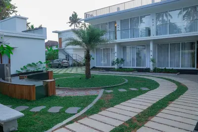 a building with a palm tree in front of it at Palm Wave Beach Resort in Cherai Beach