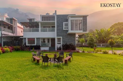 a house with a table and chairs in the yard at EKOSTAY - Apollo Villa in Kodaikānāl