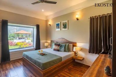 a bedroom with a bed and a large window at EKOSTAY - Apollo Villa in Kodaikānāl