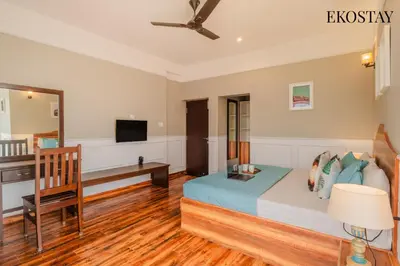 a bedroom with a bed and a desk and a television at EKOSTAY - Apollo Villa in Kodaikānāl