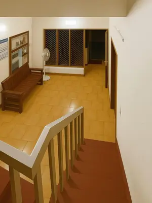 a view of a living room with a couch and a staircase at RJ Residency in Kozhikode