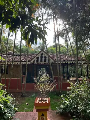a house with a potted plant in front of it at NATUREs LAP FARM STAY Mysore in Mysore