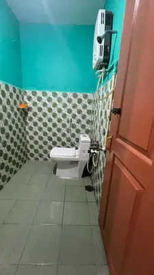 a bathroom with a white toilet in a room at Aiyappa Stayz in Madikeri