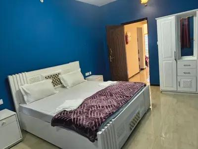a bedroom with a large bed with a blue wall at Ahavah Chalets in Ketti