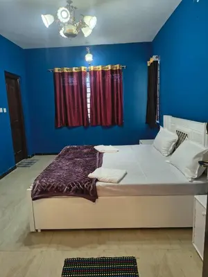 a bedroom with a large bed with a blue wall at Ahavah Chalets in Ketti