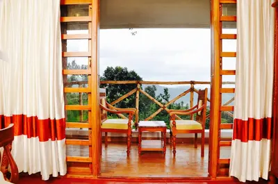 a room with a balcony with a large window at Hanging Huts Resorts in Kotagiri