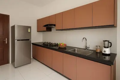 a kitchen with a sink and a refrigerator at Rajagiri View Apartments in Alwaye