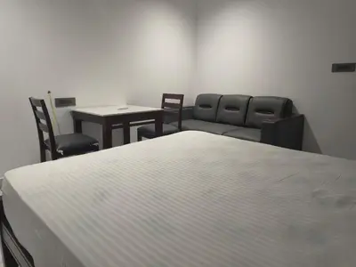 a room with a bed and chairs and a table at Rajagiri View Apartments in Alwaye