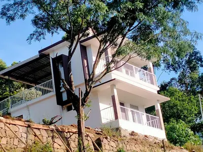 a white building on top of a rock wall at Amber Mount Resorts in Kanthalloor