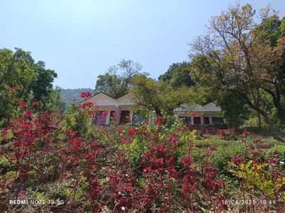 a garden with pink flowers in front of a house at Amber Mount Resorts in Kanthalloor