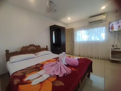 a bedroom with a bed with two dresses on it at Ponkunnu Farmstay and Resorts - Emerald - The Tree House - First Floor in Bālūssheri
