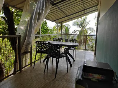 a patio with a table and chairs on a balcony at Ponkunnu Farmstay and Resorts - Emerald - The Tree House - First Floor in Bālūssheri