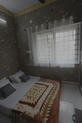 a bedroom with a bed and a window with leaves on the wall at Coconut Sooru,Managed By Triora Escapes in Maddūr
