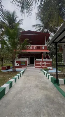 a red and white building with a palm tree at Coconut Sooru,Managed By Triora Escapes in Maddūr