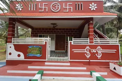 a house with a red and white building at Coconut Sooru,Managed By Triora Escapes in Maddūr