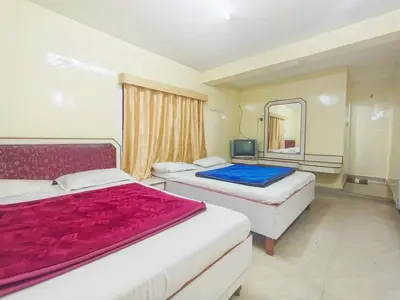 a hotel room with two beds and a mirror at BKC Lakshmi Cottage in Ooty
