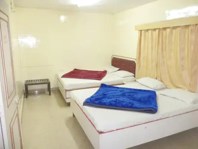 a room with three beds with blue blankets on them at BKC Lakshmi Cottage in Ooty