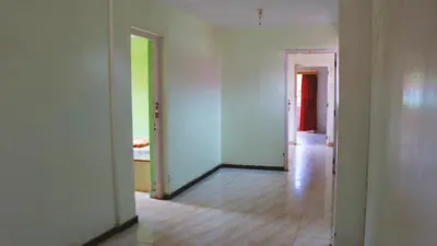 an empty room with white walls and wooden floors at BKC Lakshmi Cottage in Ooty