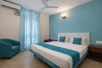 a bedroom with a large bed and a chair at Rooms By DeVerveil in Mysore