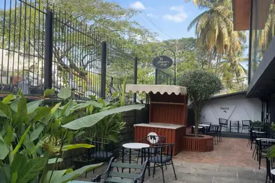 a patio with tables and chairs in a restaurant at Rooms By DeVerveil in Mysore