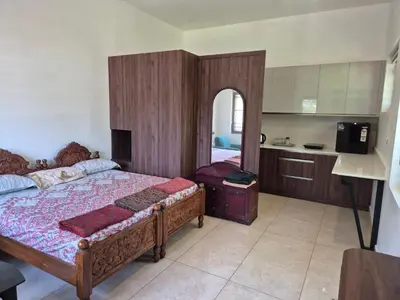 a bedroom with a large bed and a kitchen at Prabhu Villla Upper Deck in Perumbavoor