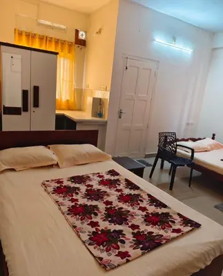 a bedroom with a bed with a flower rug on it at Darshanam Inn in Guruvāyūr