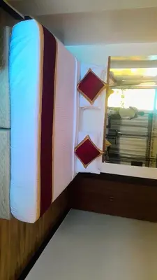 a bed with pillows and a mirror in a room at Silver lake nature escape in Ooty
