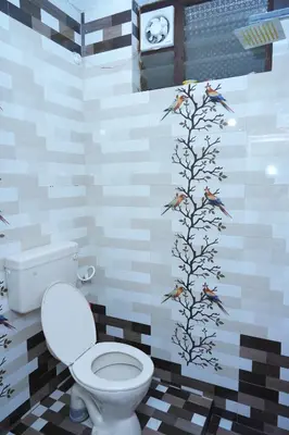 a bathroom with a toilet and birds on the wall at Sparrow valley in Coonoor