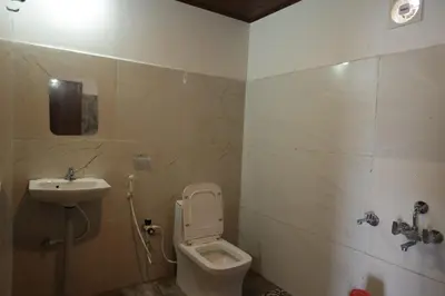 a bathroom with a toilet and a sink at Coorg Backwaters in Suntikoppa