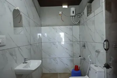 a white bathroom with a sink and a toilet at Coorg Backwaters in Suntikoppa