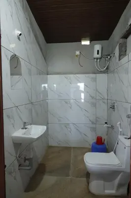 a bathroom with a toilet and a sink at Coorg Backwaters in Suntikoppa