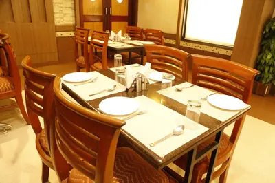 a dining room with tables and chairs in a restaurant at HOTEL GRAND PLAZzA in Coimbatore