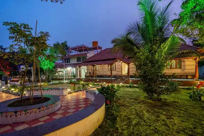 a house with a palm tree in front of it at Alaya Stays APR Pet-Friendly One-Room Suites with Swimming Pool in Bengaluru, Karnataka
