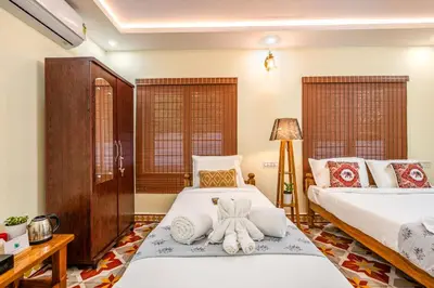 a bedroom with two beds with towels on them at Alaya Stays APR Pet-Friendly One-Room Suites with Swimming Pool in Bengaluru, Karnataka